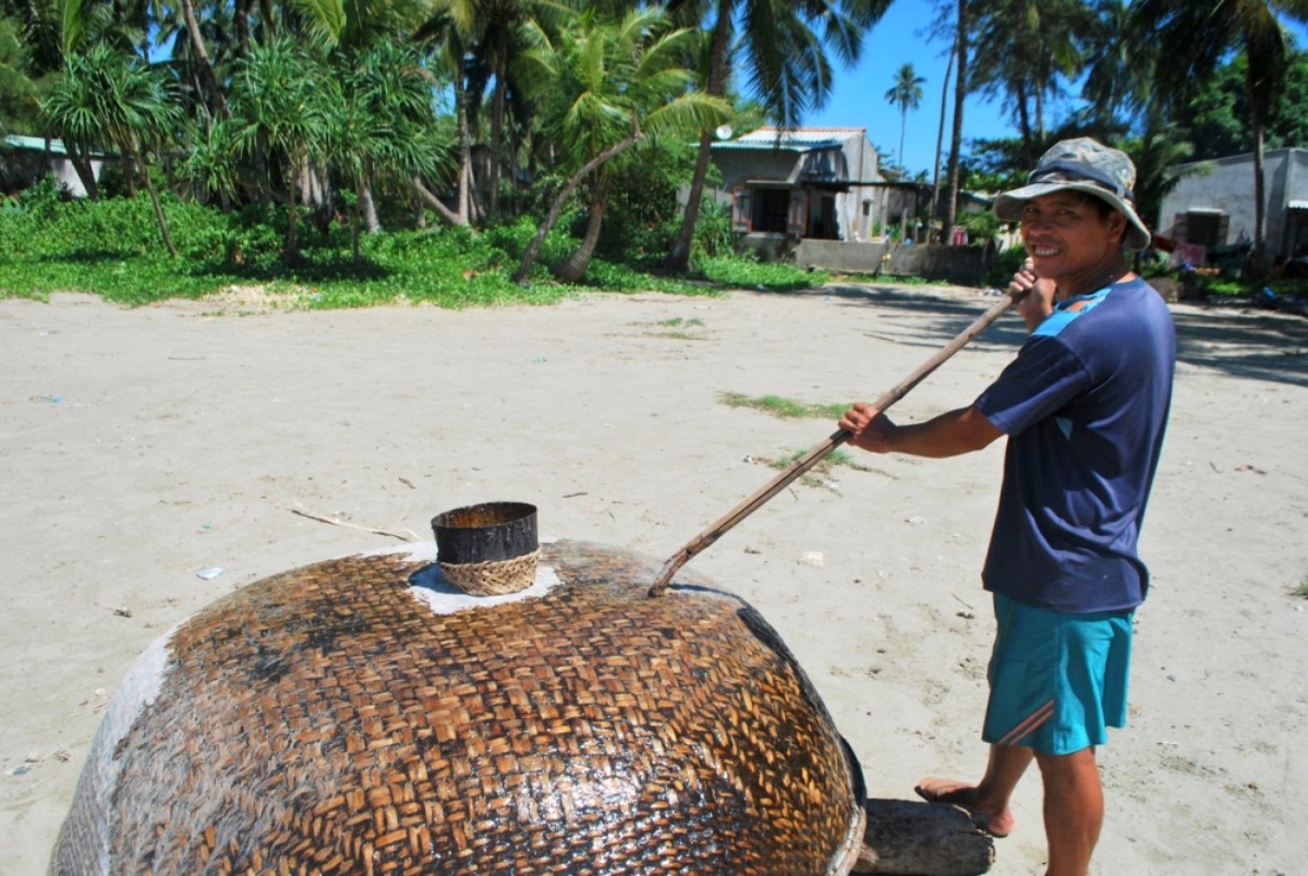 Ngư dân sửa thúng trên bãi biển