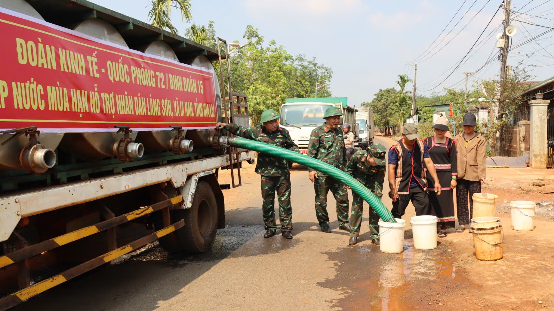 Xe bồn vào tận khu dân cư, dừng trước từng nhà để cấp nước, người dân mang dụng cụ ra nhận. 