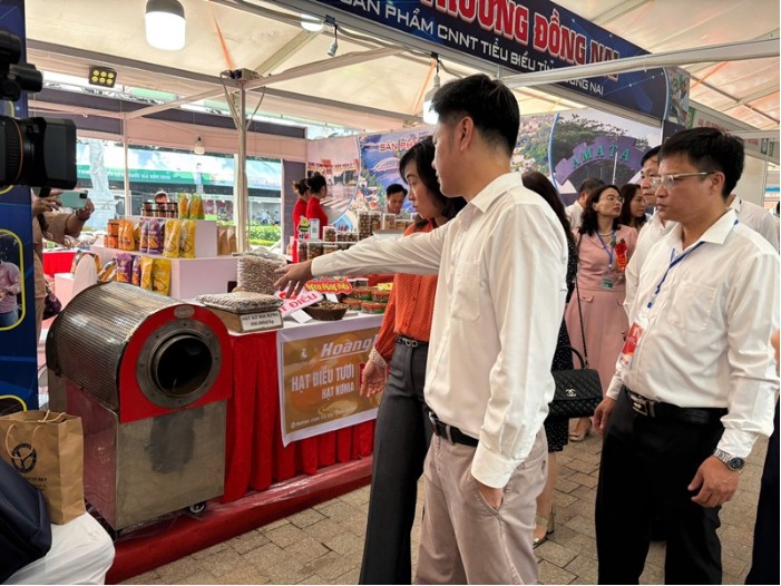 Ông Trần Minh Đạt - Giám đốc Trun g tâm Khuyến công và Tư vấn Phát triển Công  nghiệp tỉnh Đồng Nai Giới thiệu Sản phẩm CNNTTB cấp Quốc Gia năm 2025 máy  tách võ hạt điều của Công ty CP Đại Hoàng Kim Bình Phước tại Hội chợ triển lãm  hàng công nghiệp nông thôn năm 2025