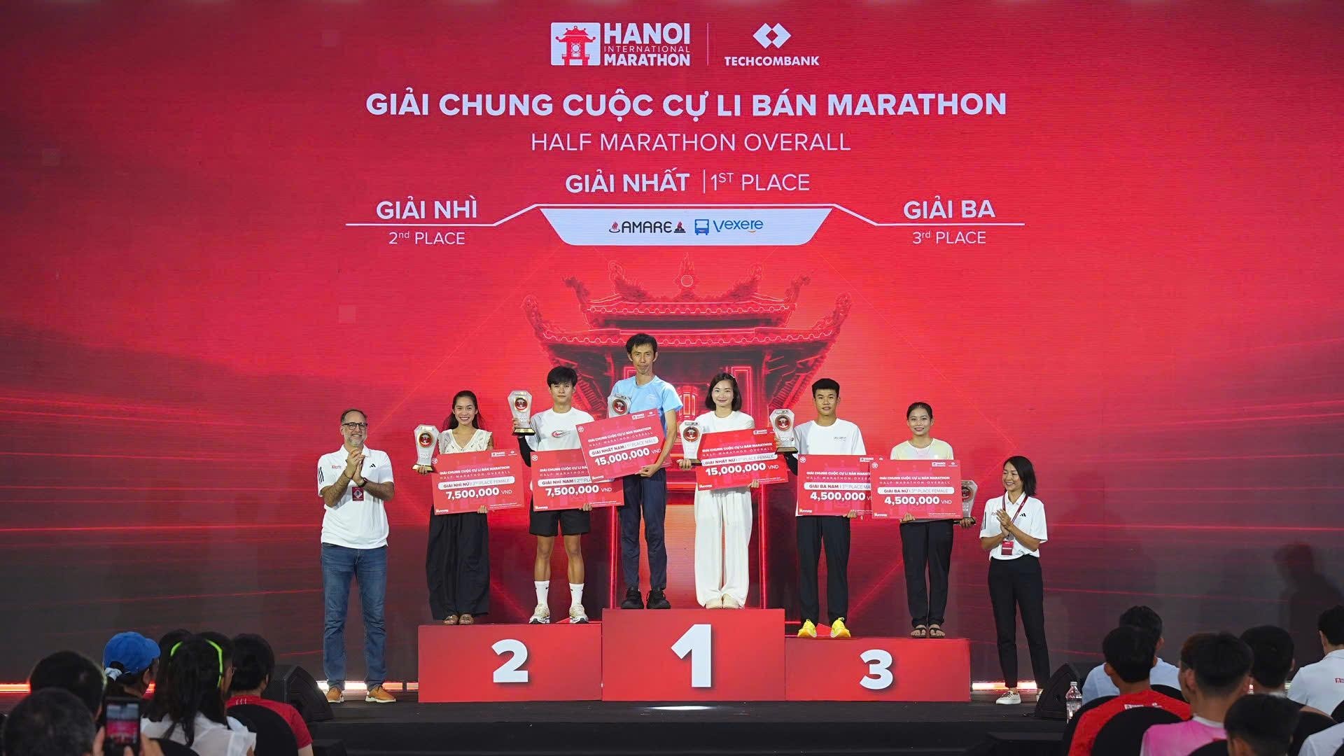 Bà Anh Võ, Tổng Giám đốc công ty Sunrise Events Vietnam (góc phải ngoài cùng) cùng ông Rob Zamacona, Cố vấn cấp cao công ty Sunrise Event Vietnam (góc trái ngoài cùng) trao giải cho top 3 chung cuộc cự ly Bán Marathon